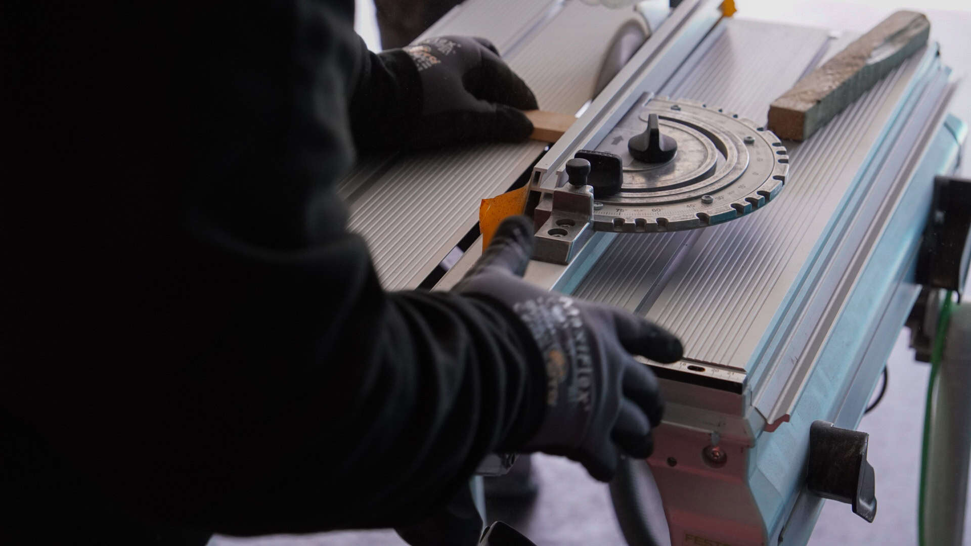 Gros plan sur les mains d'un vitrier réglant une scie de table