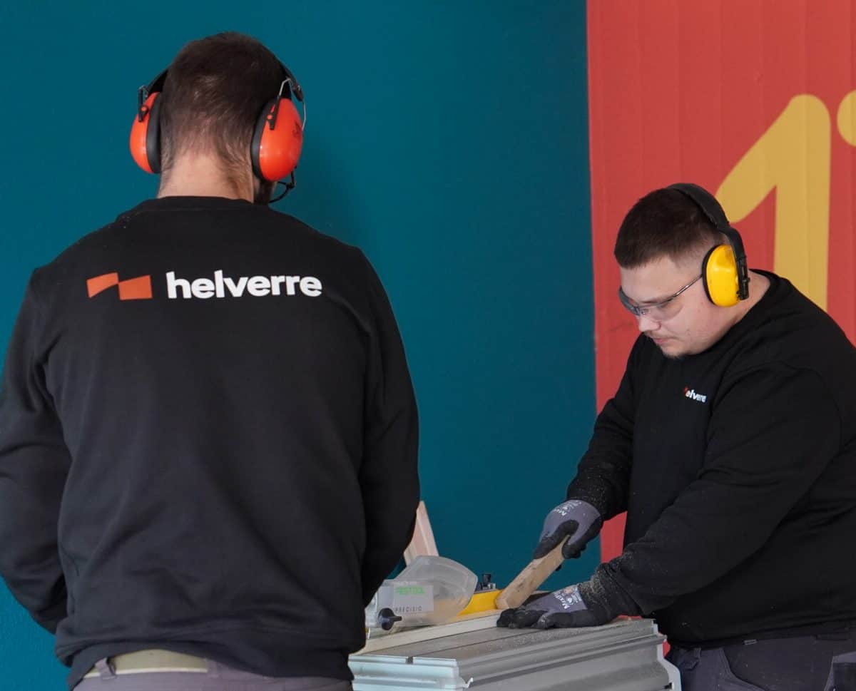 Deux vitriers Helverre travaillant ensemble sur une scie de table