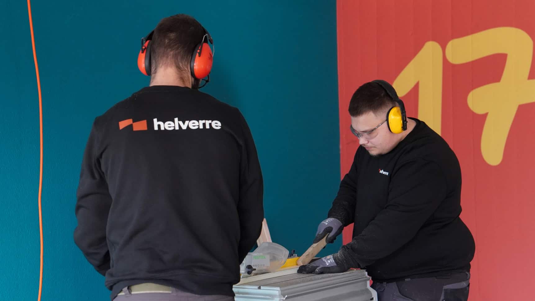 Deux vitriers Helverre travaillant ensemble sur une scie de table