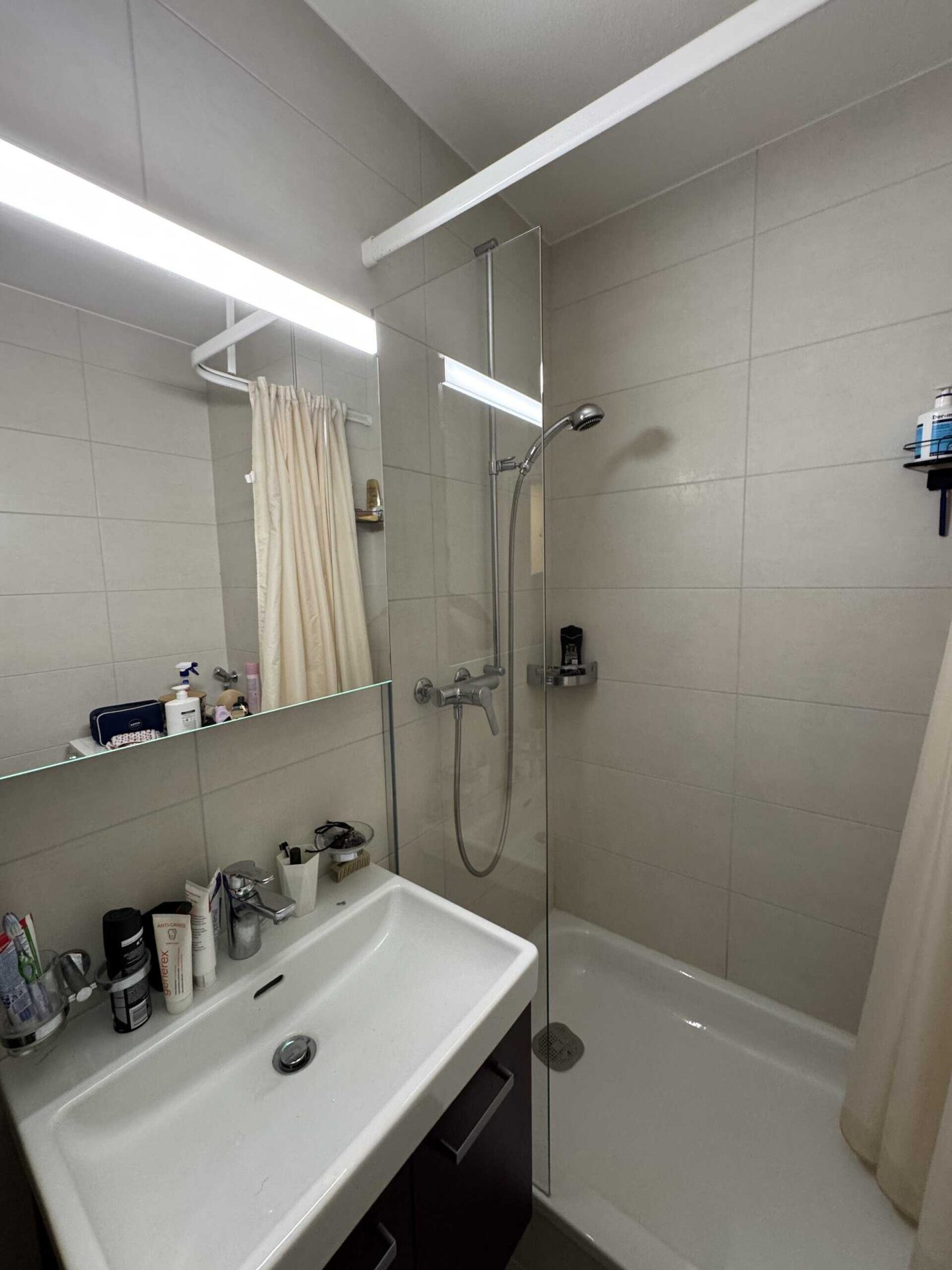Salle de bain avec pare-douche en verre et robinetterie
