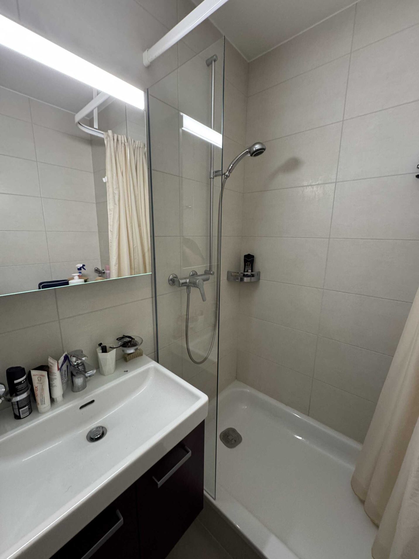 Pare-douche en verre fixe installé dans une salle de bain
