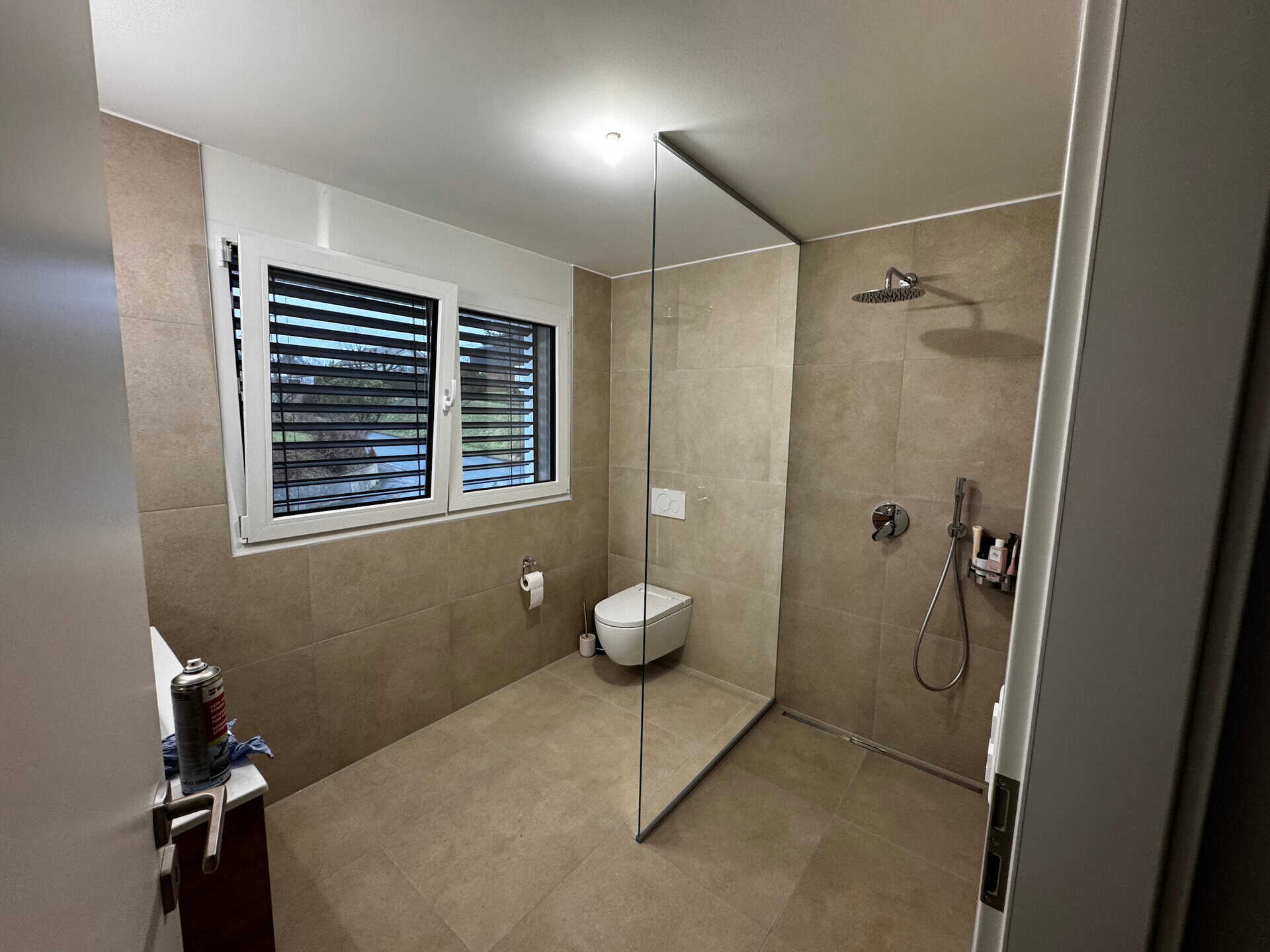 Salle de bain moderne avec paroi de douche en verre fixe