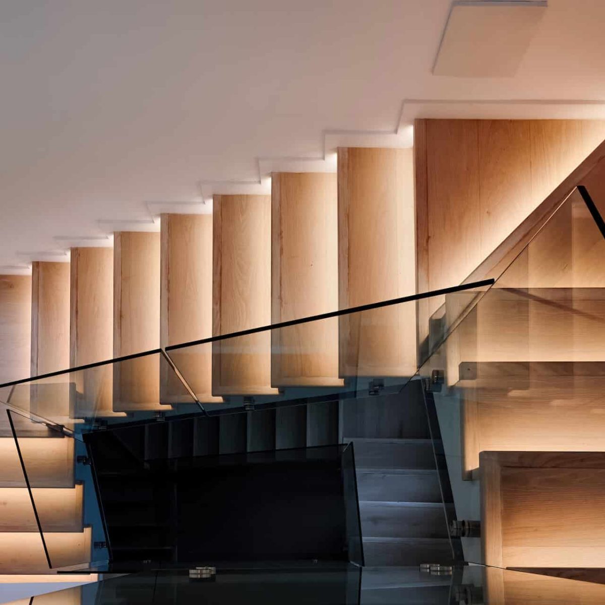 Escalier en bois dans une maison moderne avec garde-corps en verre